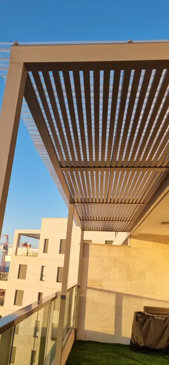 פרגולה בגוון חום־בהיר לצד קיר הבית, צילום אנכי מלמטה — ענק הצל
